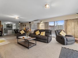 A living room with a sofa and coffee table at Raglan Holiday Home in Raglan