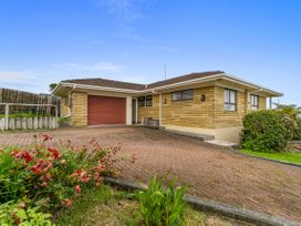 A house with a garage and driveway at Raglan Holiday Home in Raglan