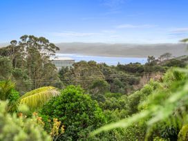 A view of trees and ocean at Raglan Holiday Home in Raglan