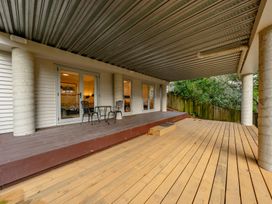 An outdoor patio with chairs and a table at Birdsong Retreat - Titirangi Holiday Home, Auckland