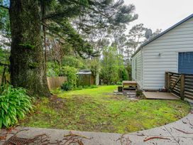 An outdoor area with grass and a tree at Birdsong Retreat - Titirangi Holiday Home Auckland