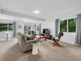 A living room with a sofa and coffee table at Birdsong Retreat - Titirangi Holiday Home Auckland