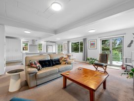 A living room with a sofa and coffee table at Birdsong Retreat - Titirangi Holiday Home in Auckland