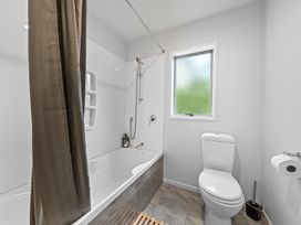 A bathroom with a bathtub and toilet at Birdsong Retreat - Titirangi Holiday Home, Auckland