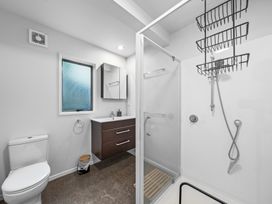 A bathroom with a shower and sink at Birdsong Retreat - Titirangi Holiday Home, Auckland