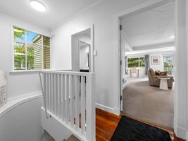 A hallway with a staircase leading to a living area at Birdsong Retreat - Titirangi Holiday Home, Auckland