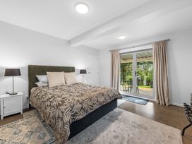 A bedroom with a bed and nightstands at Birdsong Retreat - Titirangi Holiday Home, Auckland