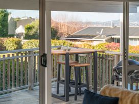 A table with stools and glasses at The Cozy Corner - Taupo Holiday Home in Acacia Bay