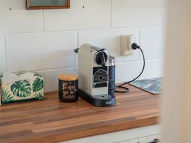 A kitchen countertop with a coffee machine and mug at The Cozy Corner - Taupo Holiday Home in Acacia Bay
