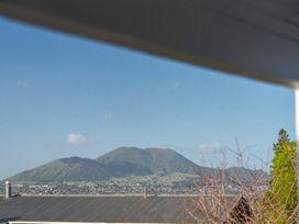A view of mountains and buildings from The Cozy Corner - Taupo Holiday Home in Acacia Bay
