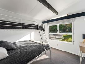 A bedroom with a bunk bed and a desk at The Cozy Corner - Taupo Holiday Home located in Acacia Bay