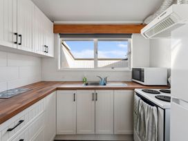 A kitchen with sink and stove at The Cozy Corner - Taupo Holiday Home in Acacia Bay