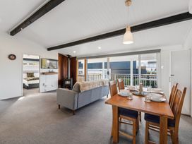 A living room with a dining table and sofa at The Cozy Corner - Taupo Holiday Home in Acacia Bay