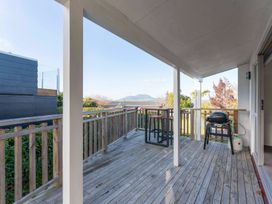 A deck with a table and barbecue at The Cozy Corner - Taupo Holiday Home Acacia Bay