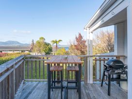 An outdoor deck with a table and chairs at The Cozy Corner - Taupo Holiday Home Acacia Bay