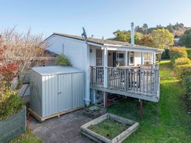 A house with a deck and storage shed at The Cozy Corner - Taupo Holiday Home Acacia Bay