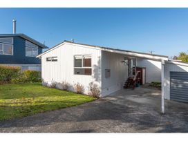 A house with a driveway and front steps at The Cozy Corner - Taupo Holiday Home, Acacia Bay
