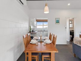 A dining room with a table and chairs at The Cozy Corner - Taupo Holiday Home in Acacia Bay