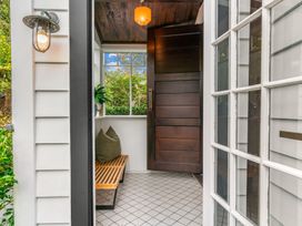 An entryway with a bench and window at Board and Batten - Matakana Holiday Home, Matakana
