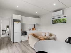 A kitchen with a refrigerator and microwave at Board and Batten - Matakana Holiday Home, Matakana