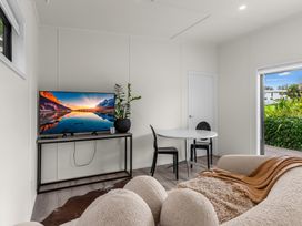 A living room with a television and dining table at Board and Batten - Matakana Holiday Home Matakana