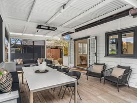 An outdoor living area with a table and chairs at Board and Batten - Matakana Holiday Home in Matakana