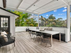 A deck with a dining table and chairs at Board and Batten - Matakana Holiday Home, Matakana