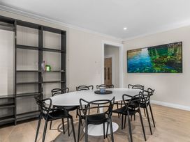 A dining room with a round table and chairs at Board and Batten - Matakana Holiday Home in Matakana