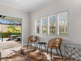 A living room with chairs and a table at Board and Batten - Matakana Holiday Home in Matakana