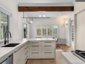 A kitchen with a sink and cabinets at Board and Batten - Matakana Holiday Home in Matakana