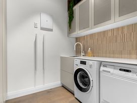 A laundry room with a washing machine and dryer at Board and Batten - Matakana Holiday Home in Matakana