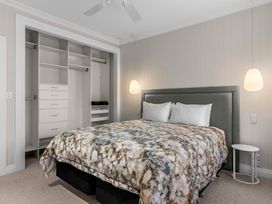 A bedroom with a bed and closet at Board and Batten - Matakana Holiday Home in Matakana