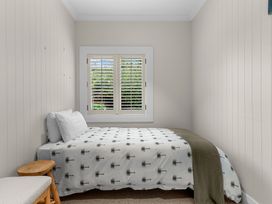 A bedroom with a bed and window at Board and Batten - Matakana Holiday Home in Matakana
