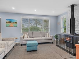 A living room with a sofa, footstool, and a stove at Bayview Haven - Waikawa Retreat in Picton