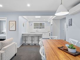 A dining area with a table and kitchen island at Bayview Haven - Waikawa Retreat in Picton