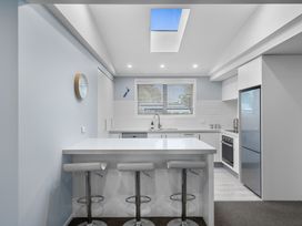 A kitchen with a counter and stools at Bayview Haven - Waikawa Retreat in Picton
