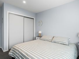 A bedroom with a bed and nightstand at Bayview Haven - Waikawa Retreat in Picton