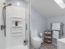 A bathroom with a shower, toilet, and towel rack at Bayview Haven - Waikawa Retreat in Picton