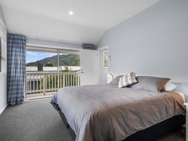 A bedroom with a bed and curtains at Bayview Haven - Waikawa Retreat in Picton