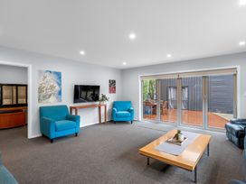 A living room with two chairs, a coffee table, and a television at Bayview Haven - Waikawa Retreat in Picton