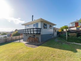 A house with a balcony and wood pile at Taupo view road holiday home, Taupo