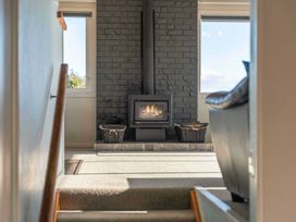 A living room with a fireplace and stairs at Taupo view road holiday home in Taupo