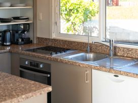 A kitchen with a sink, stove, and coffee maker at Taupo view road holiday home Taupo