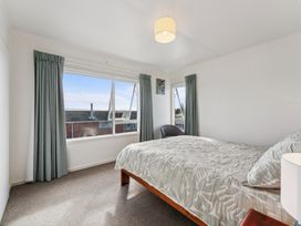 A bedroom with a bed and chair at Taupo view road holiday home, Taupo