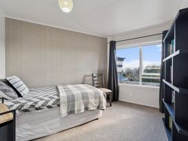 A bedroom with a bed and bookshelf at Taupo view road holiday home in Taupo
