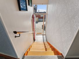 A staircase with a handrail and a door at Taupo view road holiday home Taupo