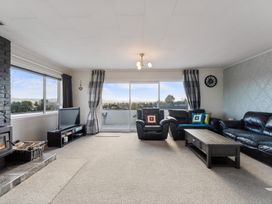 A living room with a fireplace and television at Taupo view road holiday home in Taupo