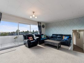 A living room with sofas and a table at Taupo view road holiday home in Taupo