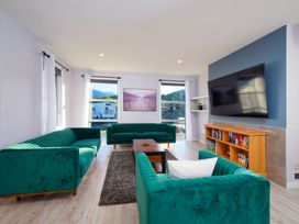 A living room with green sofas and a television at Kaikoura