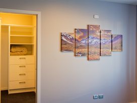 A bedroom with a closet and wall art at Kaikoura